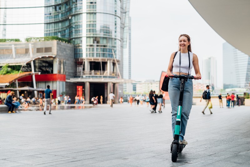 E-Scooter mit Frau in Stadt